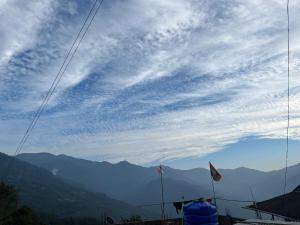 a view of a cloudy sky with mountains in the background at Elves Homestay in Rhenok