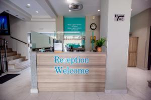 a reception desk in a lobby with a reception welcome sign at Amalia Mare in Nea Vrasna