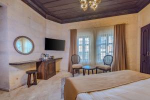 a hotel room with a bed and a television at Castellum Cave Cappadocia in Uçhisar