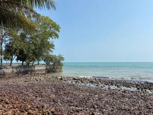a rocky beach with trees and the ocean at Issara Beach Resort in Sichon