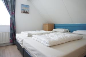 two twin beds in a room with a window at Kustverhuur , Park Scheldeveste, Zwin 143 in Breskens +18 photos