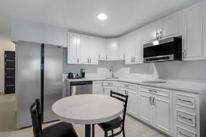 a kitchen with white cabinets and a table and chairs at Blue A Modern Hotel, an Ascend Collection Hotel in West Springfield