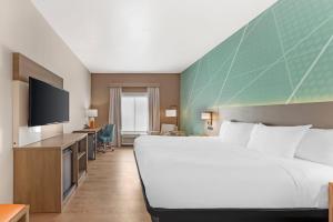 a hotel room with a large bed and a flat screen tv at Comfort Inn Sullivan in Sullivan