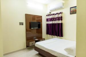 a bedroom with a bed and a tv in it at SKS Residensy in Kāraikkudi