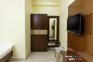 a living room with a tv and a couch at SKS Residensy in Kāraikkudi +4 photos
