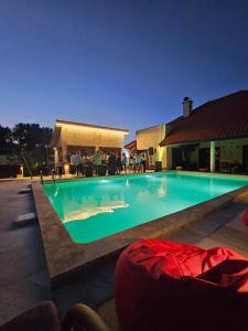 a swimming pool at night with people sitting around it at Boletov raj lux in Čurug