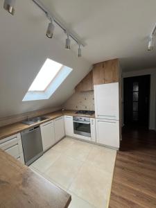 a kitchen with white cabinets and a skylight at Apartament na poddaszu in Sandomierz +27 photos