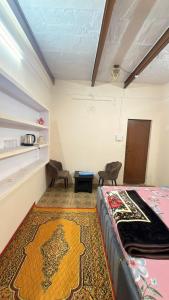 a bedroom with a bed and a rug at Tandon Lodge On The Ganga Ghat Homestay in Varanasi