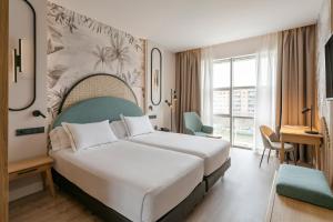 a hotel room with a bed and a large window at Vincci Maritimo in Barcelona