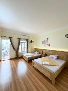 two beds in a room with wooden floors at Hương Dịu Hotel đảo Quan Lạn in Quan Lạn +10 photos
