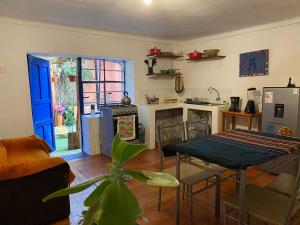 a living room with a table and a kitchen at Authentic Peruvian home with gorgeous patio in Pisac
