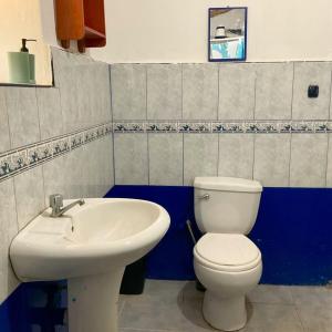 a bathroom with a white toilet and a sink at Authentic Peruvian home with gorgeous patio in Pisac +13 photos