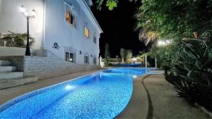 a swimming pool in front of a building at night at Silver Coast Pool & Resort Villas in Arnal