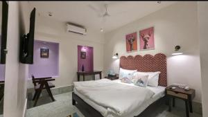 a bedroom with a large bed with purple walls at Boho Villa Mount Abu in Mount Ābu