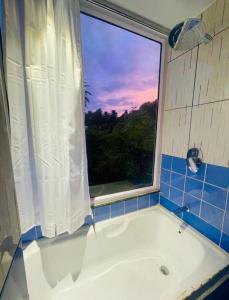 a bath tub in a bathroom with a window at Boho Villa Mount Abu in Mount Ābu