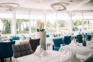 a dining room with white tables and blue chairs at DämeritzSeehotel in Berlin