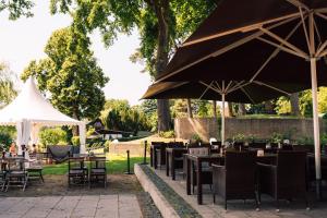 a group of tables and chairs with umbrellas at DämeritzSeehotel in Berlin