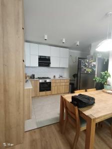 a kitchen with a wooden table and a refrigerator at Tbilisi Dirsi Complex in Tbilisi City