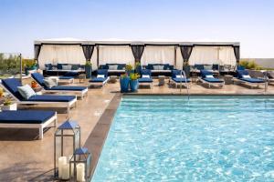 a swimming pool with blue lounge chairs and a swimming pool at ViewPoint Suites in Los Angeles