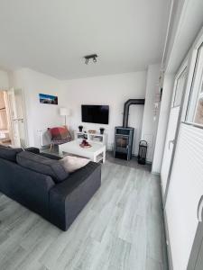 a living room with a couch and a tv at Strandläufer in Tossens