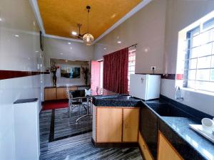 a kitchen with black counter tops and a dining room at Hotel GVS Residency in Yercaud