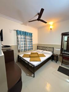 a bedroom with a bed and a ceiling fan at Manjusri Paradise in Bangalore