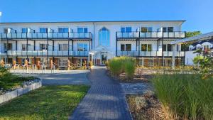 a large white building with a walkway in front of it at R&R Hotel Störtebeker in Baabe