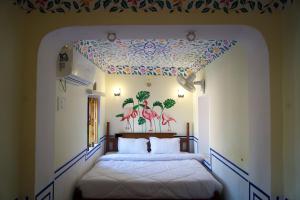 a bedroom with two beds with a floral ceiling at Bagh Ajabgarh in Ajabgarh