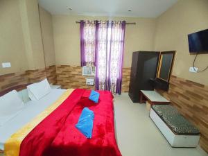 a bedroom with a large bed with a red blanket at Hotel Ishaan International Near Yatra Parchi Counter 2 in Katra