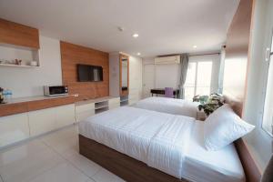 a hotel room with two beds and a tv at The Seasons in Pathum Thani
