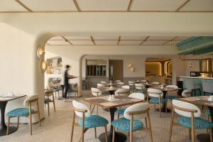 a restaurant with tables and chairs and a person in the background at Marni Pattaya in Pattaya South