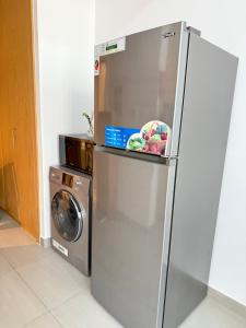 a refrigerator in a kitchen with a washing machine at Modern studio with pool and fiber connection in Sharjah