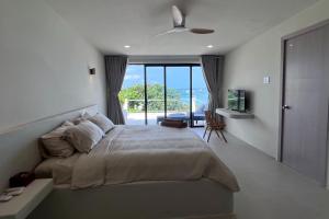 a bedroom with a bed and a view of the ocean at Anchovy Beachfront Villas in Phú Quốc