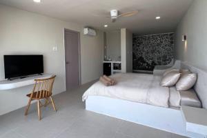 a bedroom with a large bed and a television at Anchovy Beachfront Villas in Phú Quốc