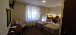 ein Hotelzimmer mit zwei Betten und einem Fenster in der Unterkunft Gilija in Šilutė