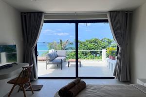 a bedroom with a view of the ocean at Anchovy Beachfront Villas in Phú Quốc +17 photos