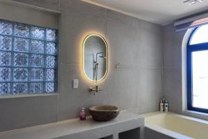 a bathroom with a sink and a tub and a mirror at Anchovy Beachfront Villas in Phú Quốc