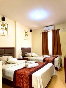 a hotel room with two beds in it at Isla Boracay Inn in Boracay