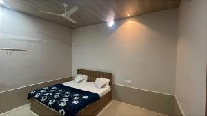 a bedroom with a bed and a ceiling fan at Hotel Moonlight in Chhatikara