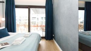 a bedroom with two beds and a large window at Sol Marina - Lazur in Wiślinka