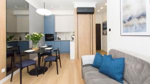 a living room and kitchen with a couch and a table at Sol Marina - Lazur in Wiślinka