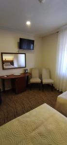 ein Hotelzimmer mit Bett, Schreibtisch und Spiegel in der Unterkunft Gilija in Šilutė