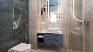 a bathroom with a sink and a toilet and a mirror at Sol Marina - Lazur in Wiślinka
