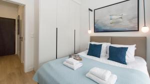 a bedroom with a blue and white bed with two pillows at Sol Marina - Lazur in Wiślinka