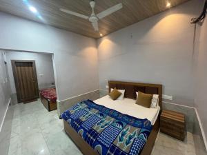 a bedroom with a bed and a ceiling fan at Hotel Moonlight in Chhatikara