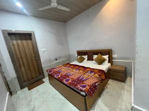 a bedroom with a bed with a wooden frame and a door at Hotel Moonlight in Chhatikara