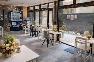 a restaurant with tables and chairs and windows at 心斎橋難波関空直通Nambaminami direct to Shinsaibashi Ambers Hostel in Osaka