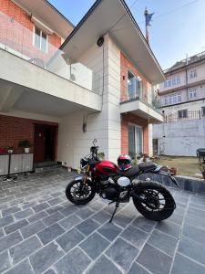 a red motorcycle parked in front of a house at Zen space in Pātan
