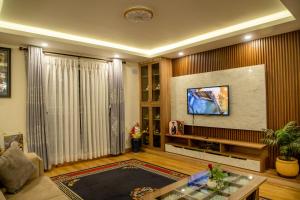 a living room with a flat screen tv on a wall at Zen space in Pātan