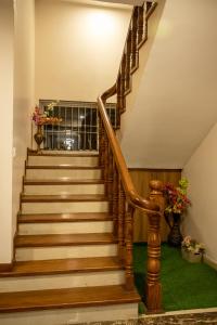 a staircase with wooden railings and green carpet at Zen space in Pātan